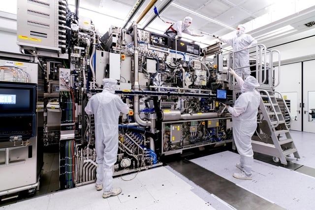 Cleanroom technicians inspect a large photolithography machine